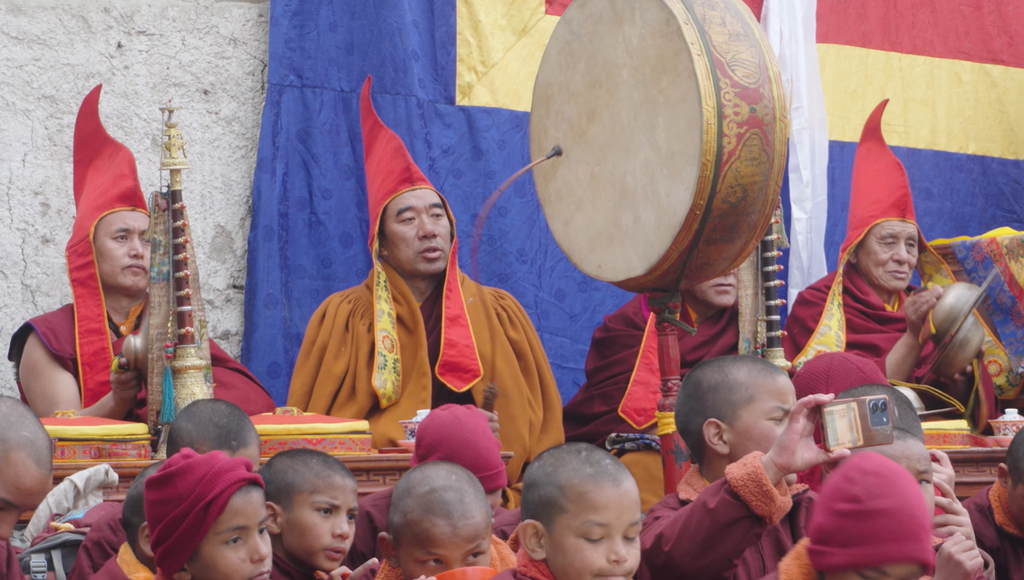 Monks in red hats and flags engage in traditional rituals during the Mustang Tiji Festival.